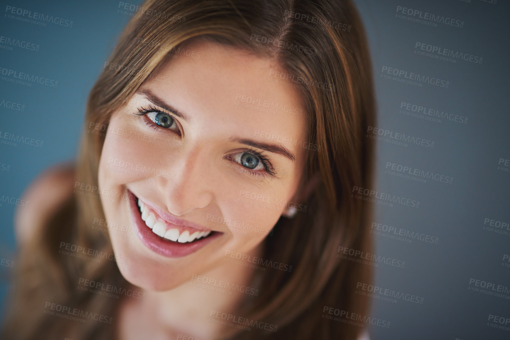 Buy stock photo High angle studio shot of an attractive young woman smiling against a gray background