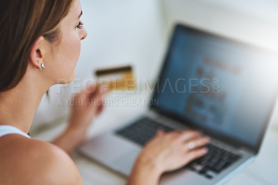 Buy stock photo Shot of a young woman using her credit card to make an online payment at home