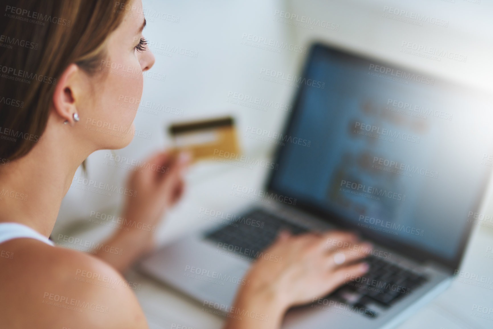 Buy stock photo Shot of a young woman using her credit card to make an online payment at home