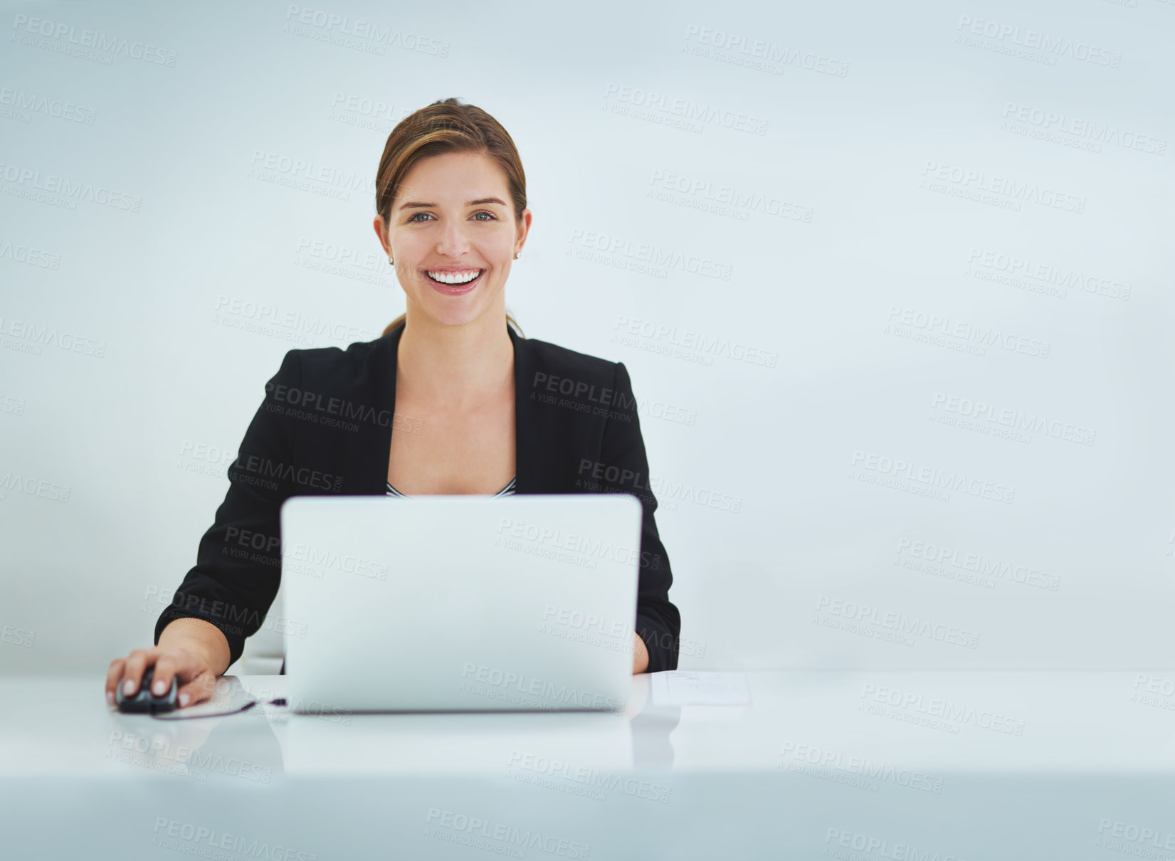 Buy stock photo Studio portrait of a young businesswoman working on her laptop