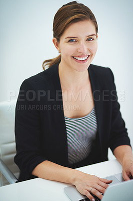 Buy stock photo Studio portrait of a young businesswoman working on her laptop