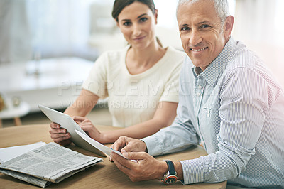 Buy stock photo Portrait of two coworkers sitting at a table discussing paperwork