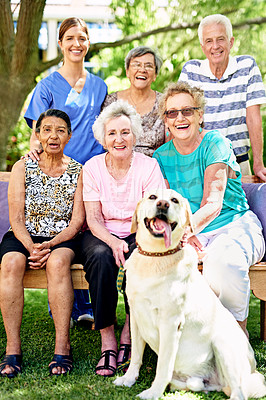 Buy stock photo Portrait of a group of smiling seniors and a nurse outside with a labrador