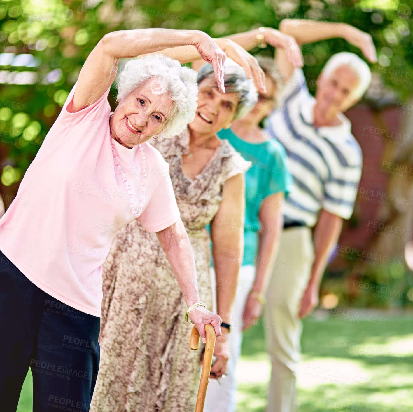 Buy stock photo Shot of a group of smiling seniors exercising outside