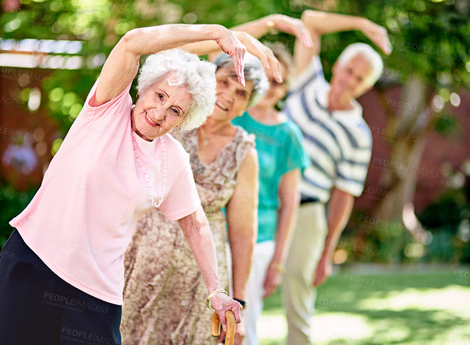 Buy stock photo Shot of a group of smiling seniors exercising outside