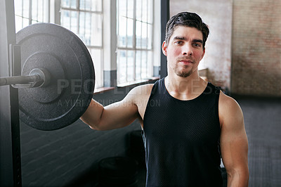 Buy stock photo Shot of a young man about to work out with weights in the gym