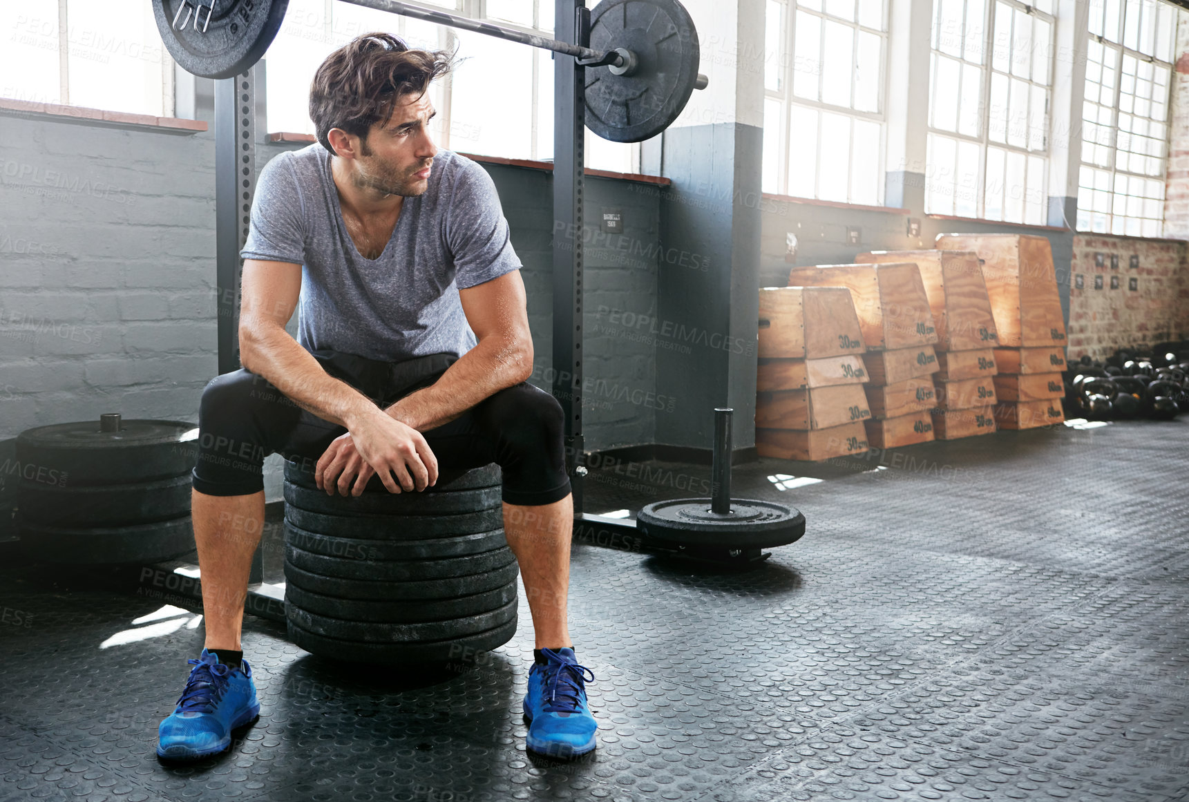 Buy stock photo Fitness, fatigue or man in gym with break, weight training or rest in intense practice. Exercise, space or athlete in studio with exhaustion, lifting pause or breath recovery in performance goal.