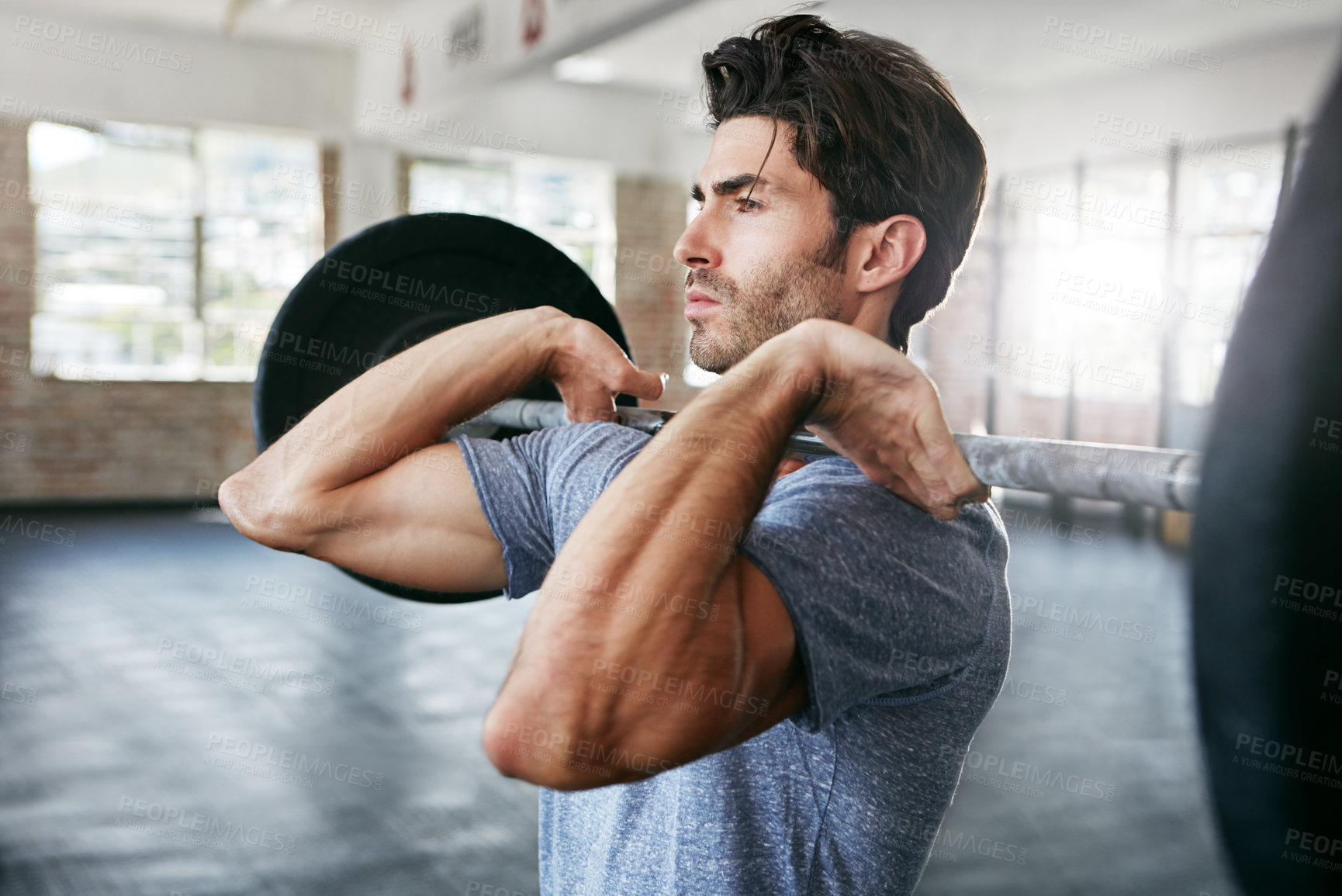 Buy stock photo Shot of a young man working out with weights in the gym