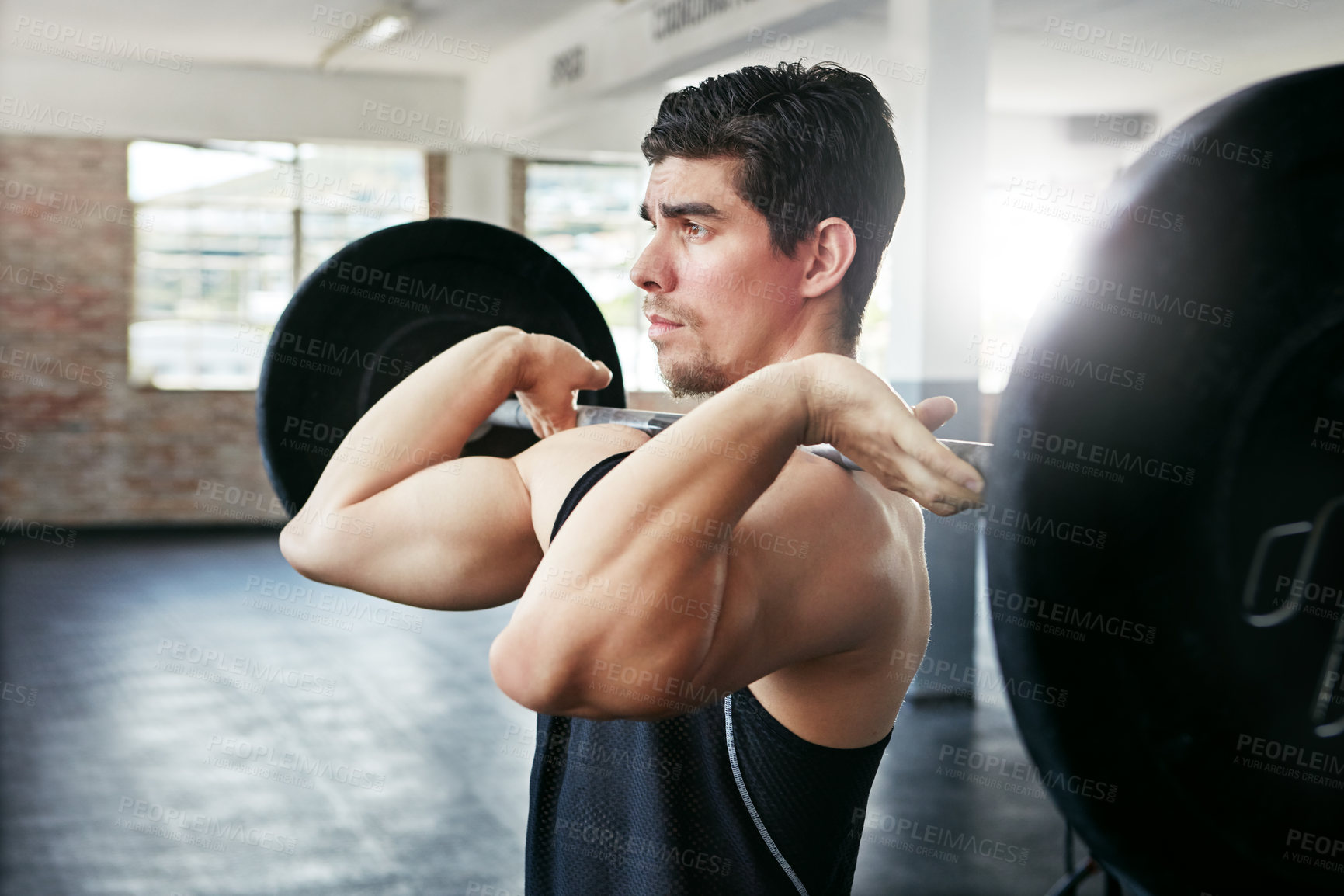 Buy stock photo Shot of a young man working out with weights in the gym