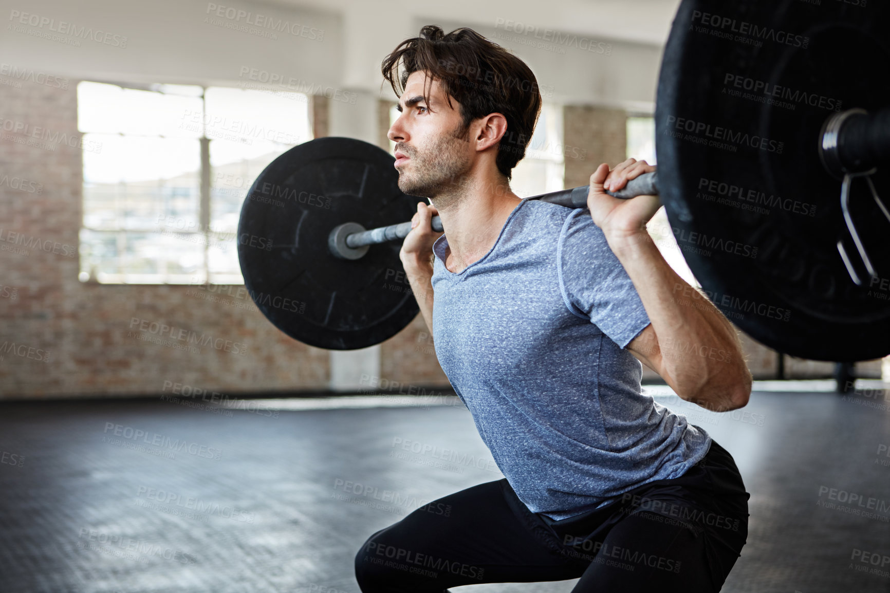 Buy stock photo Shot of a young man working out with weights in the gym