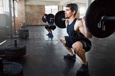 Buy stock photo Shot of young men working out with weights in the gym