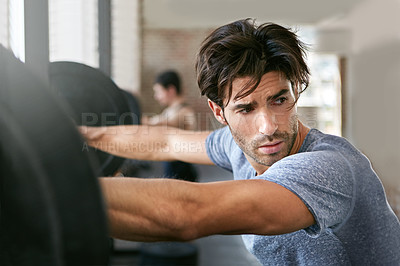 Buy stock photo Shot of a young athlete looking tired after working out in the gym