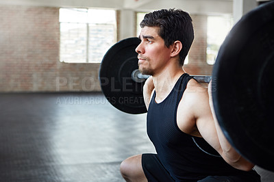 Buy stock photo Shot of a young man working out with weights in the gym