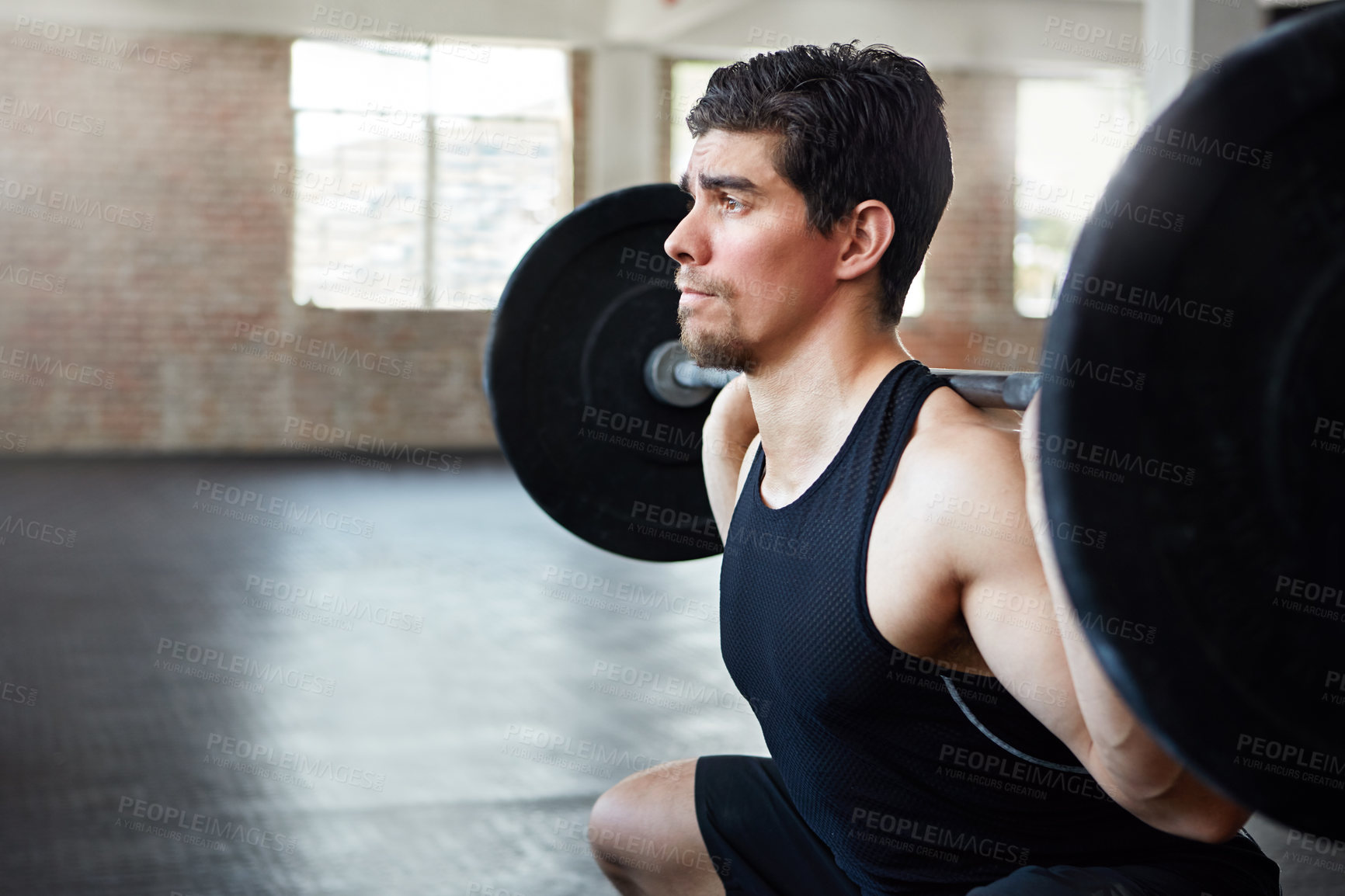 Buy stock photo Shot of a young man working out with weights in the gym