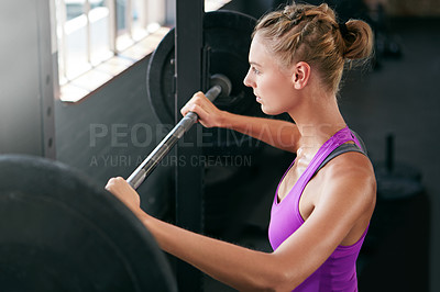 Buy stock photo Shot of a young woman working out with weights at the gym