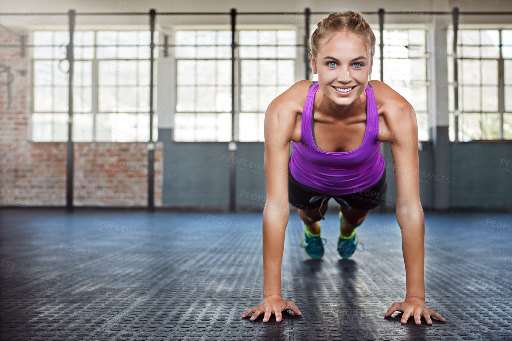 Buy stock photo Shot of a sporty young woman doing push-ups at the gym