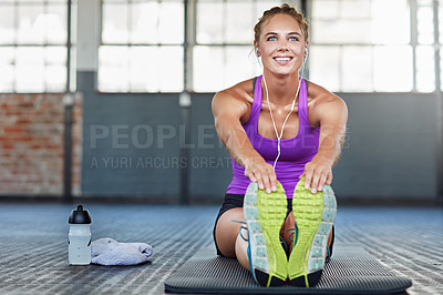 Buy stock photo Thinking, fitness and music with a woman stretching in a gym while getting ready for her workout routine. Exercise, warm up and earphones with a young female athlete training in a sports center