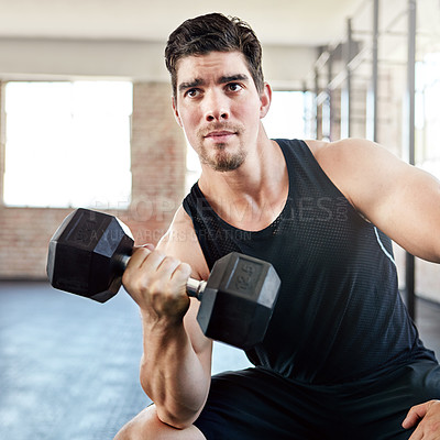 Buy stock photo Shot of a young man working out with a dumbell in the gym
