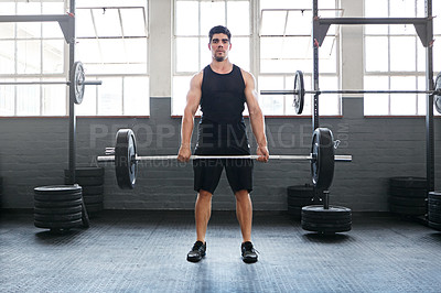 Buy stock photo Shot of a young man working out with weights in the gym