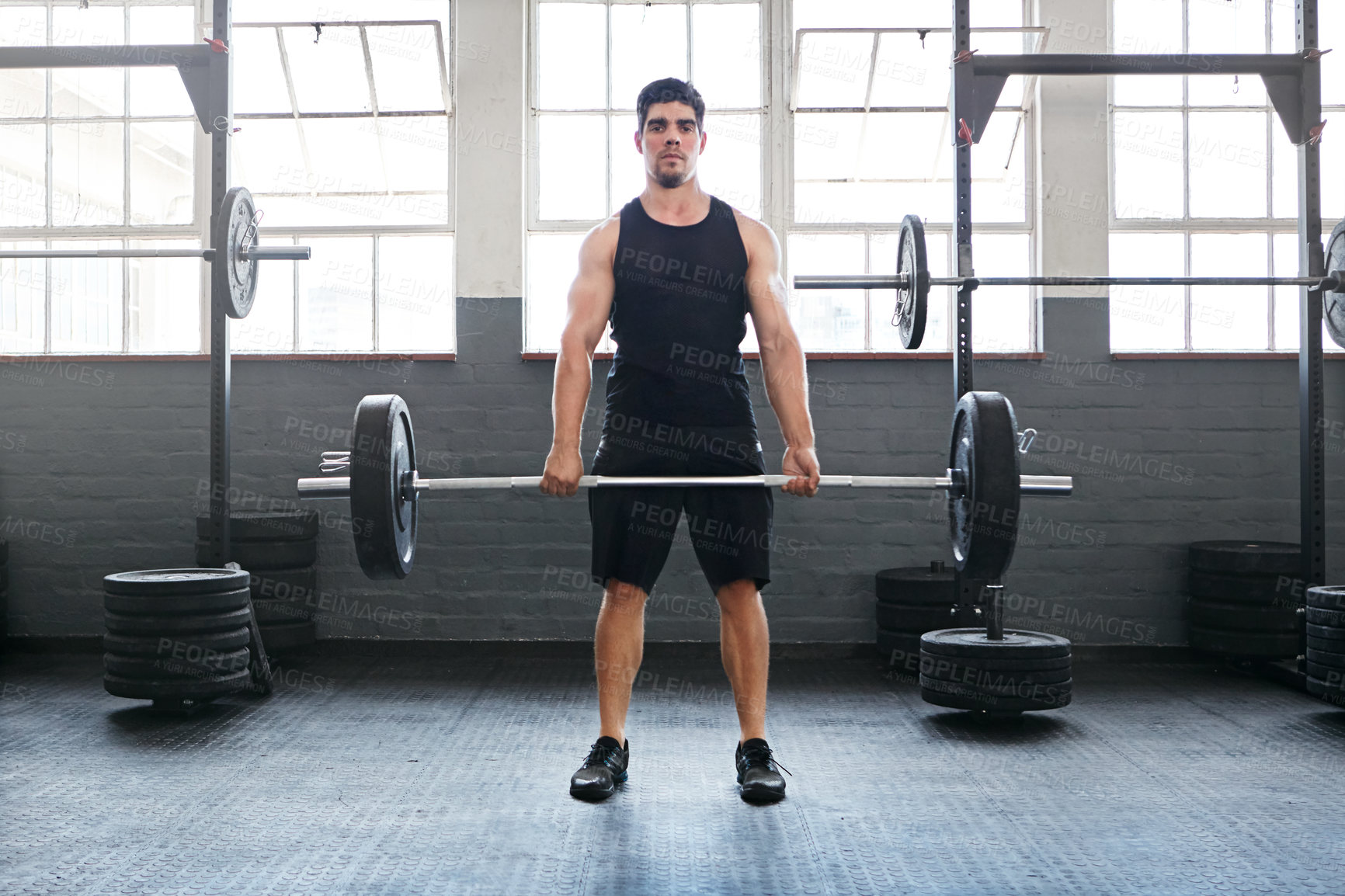 Buy stock photo Shot of a young man working out with weights in the gym