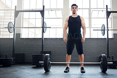 Buy stock photo Shot of a young man working out with weights in the gym