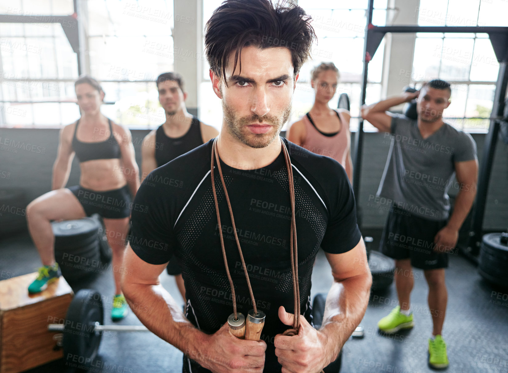 Buy stock photo Portrait of a fit young man standing in a gym with people in the background