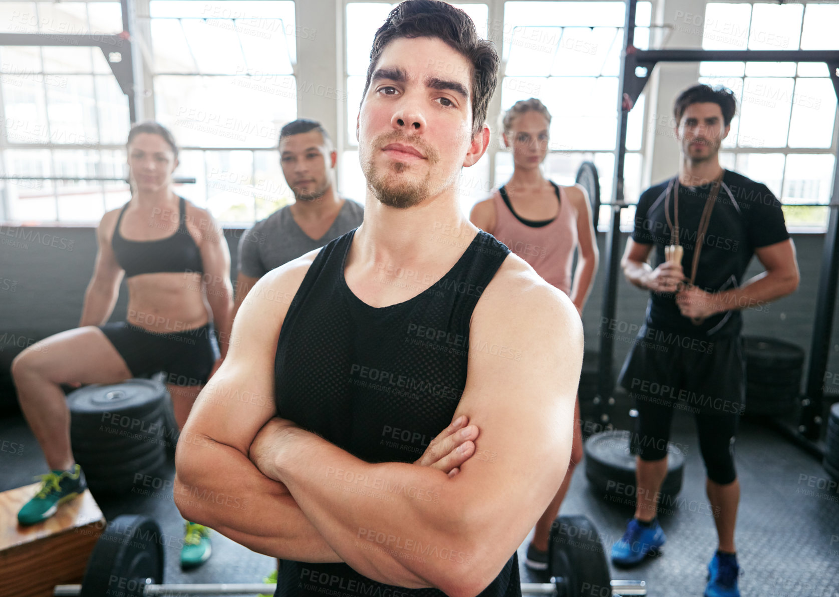 Buy stock photo Portrait of a fit young man standing in a gym with people in the background