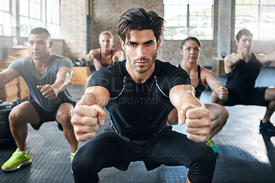 Buy stock photo Shot of a group of people doing squats in a gym
