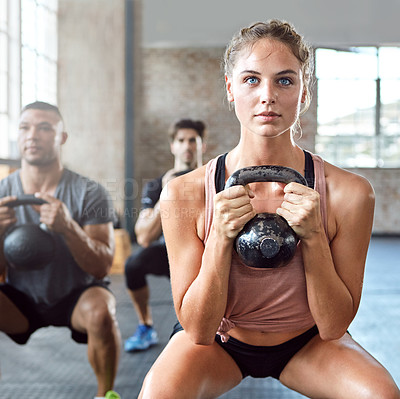 Buy stock photo Sports, kettlebell and woman doing a workout with a group for strength training in a gym. Fitness, energy and female athlete doing a exercise challenge with weights with people in a wellness center.