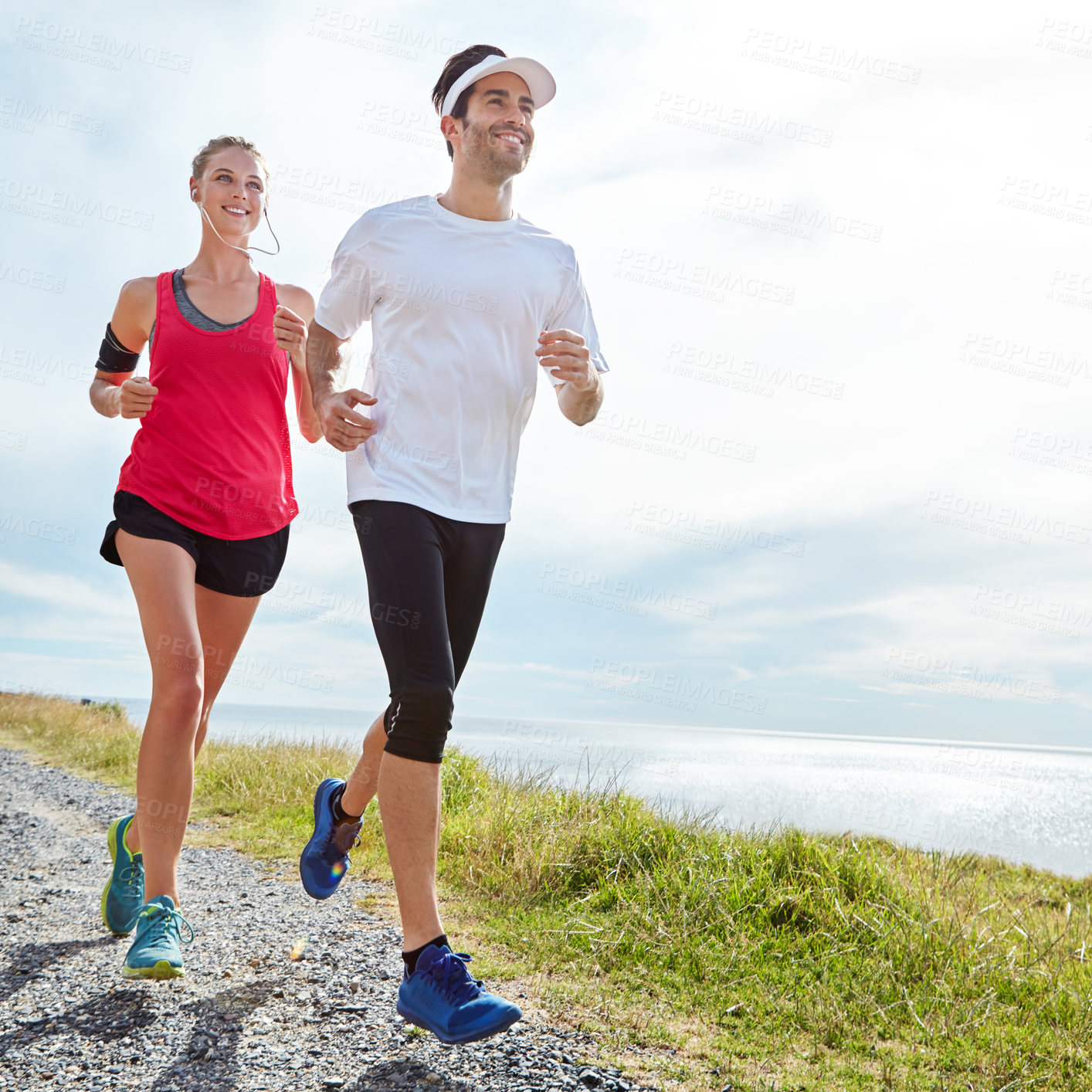 Buy stock photo Shot of a young couple going for a run together