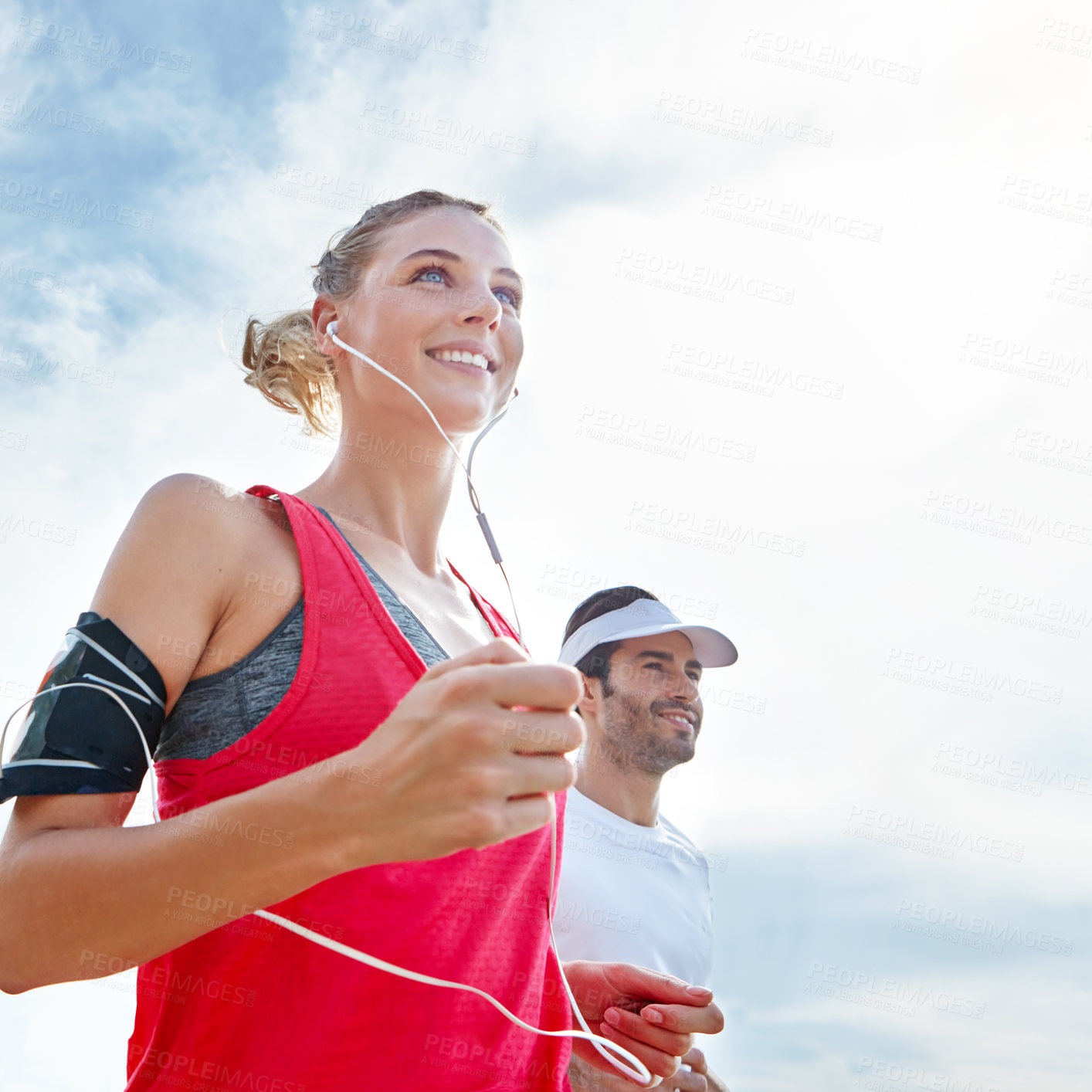 Buy stock photo Shot of a young couple going for a run together