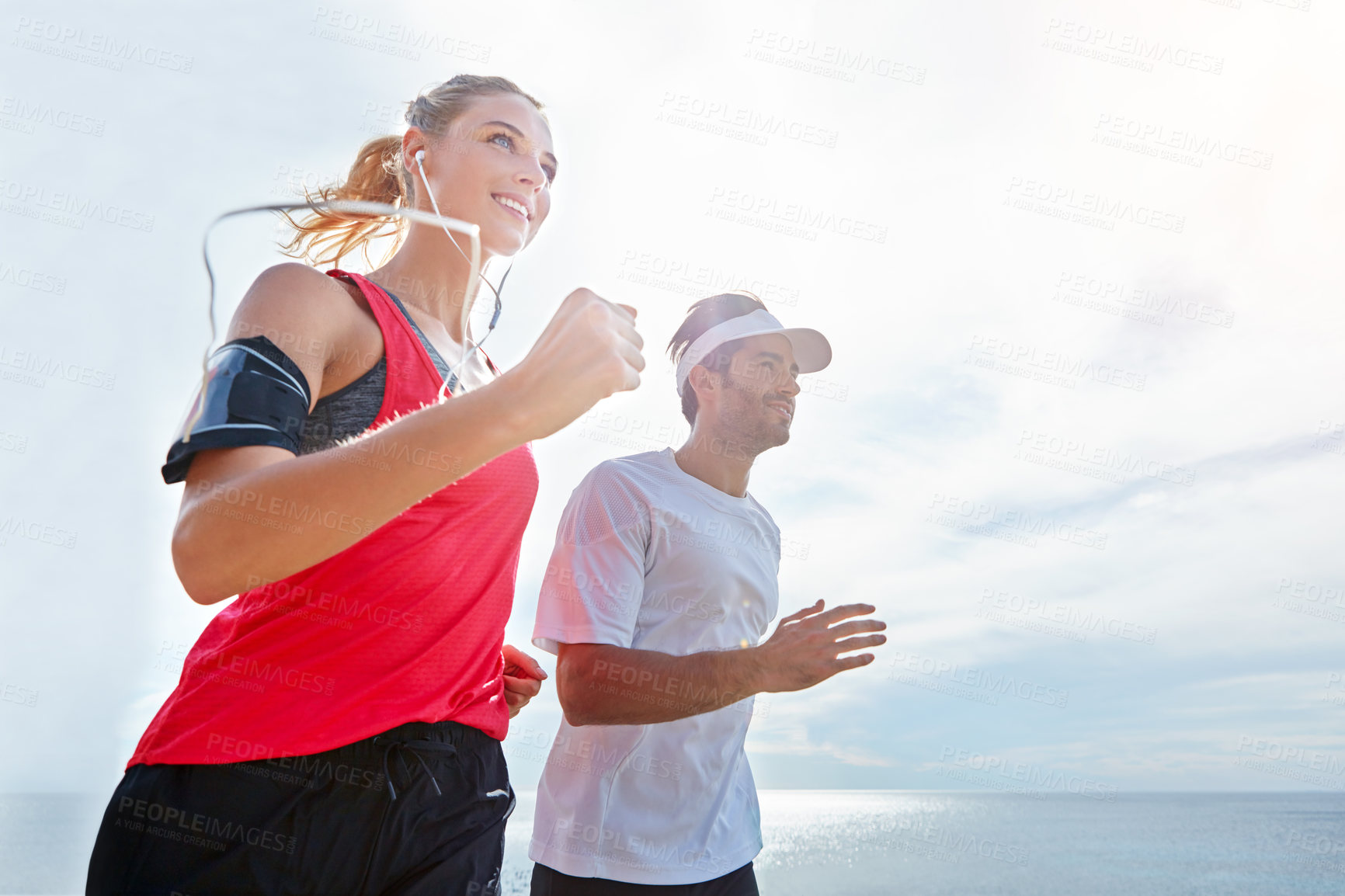 Buy stock photo Shot of a young couple going for a run together