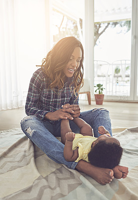 Buy stock photo Home, mom and training of legs, baby and physical therapy for development, growth and exercise in lounge. House, parent and black woman with child in living room, bonding or assistance with foot lift