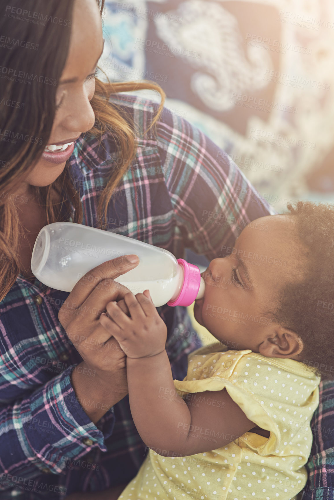 Buy stock photo Cropped shot of a young mother feeding her baby girl at home