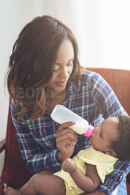 Buy stock photo Cropped shot of a young mother feeding her baby girl at home