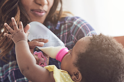 Buy stock photo Cropped shot of a young mother feeding her baby girl at home