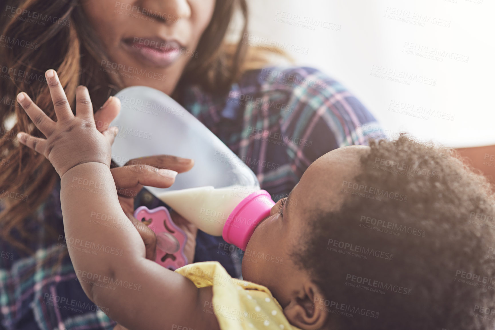 Buy stock photo Cropped shot of a young mother feeding her baby girl at home