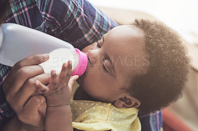 Buy stock photo Cropped shot of a mother feeding her baby girl at home