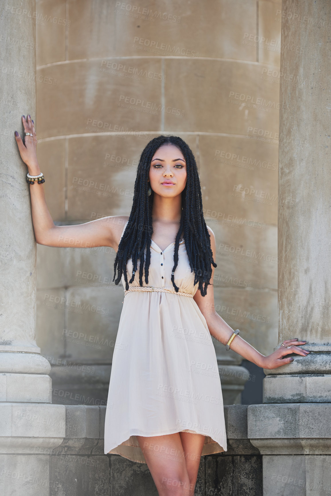 Buy stock photo Portrait of a femininely dressed young woman posing against an urban background