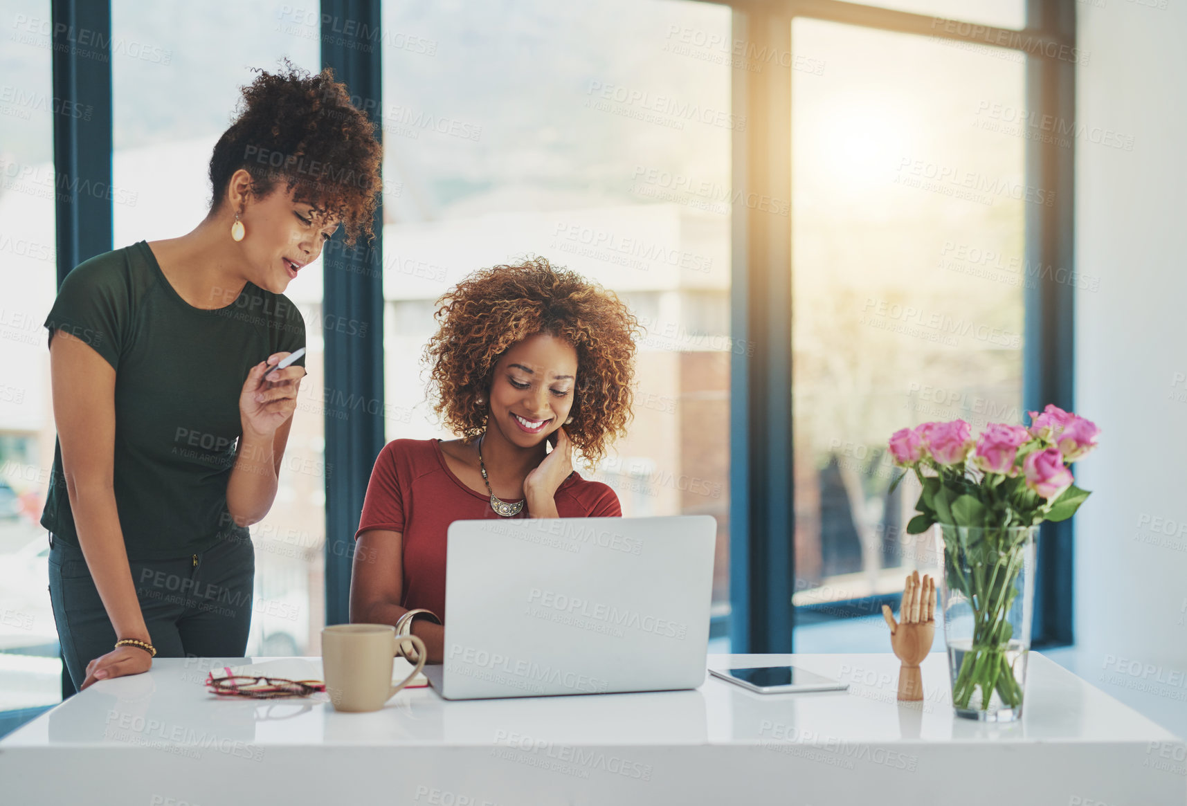 Buy stock photo Shot of two young designers working on a laptop together