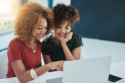 Buy stock photo Shot of two young designers working on a laptop together