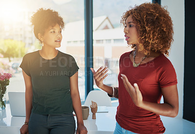 Buy stock photo Shot of two businesswomen chatting in an office