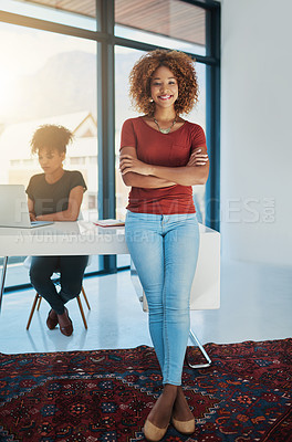 Buy stock photo Portrait of a young designer with her colleague blurred in the background