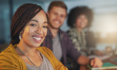 Buy stock photo Cropped portrsit of a young woman working late with her colleagues in the office