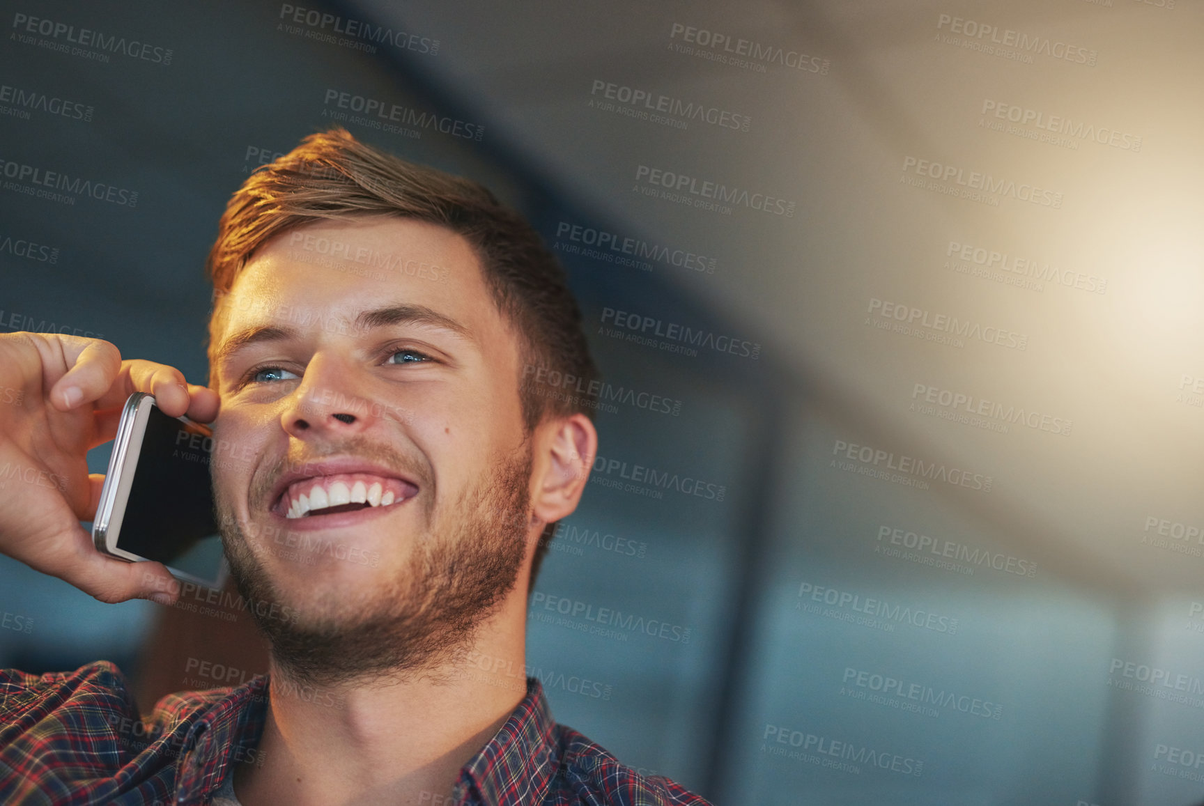 Buy stock photo Cropped shot of a young man using his cellphone while working late in the office