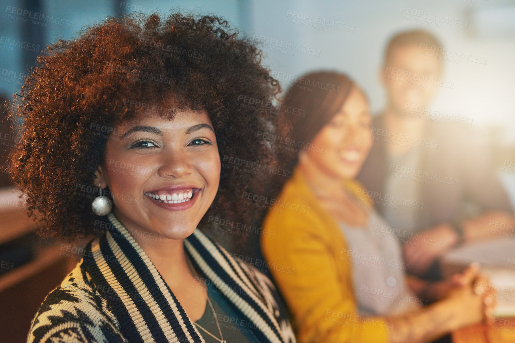 Buy stock photo Cropped portrsit of a young woman working late with her colleagues in the office