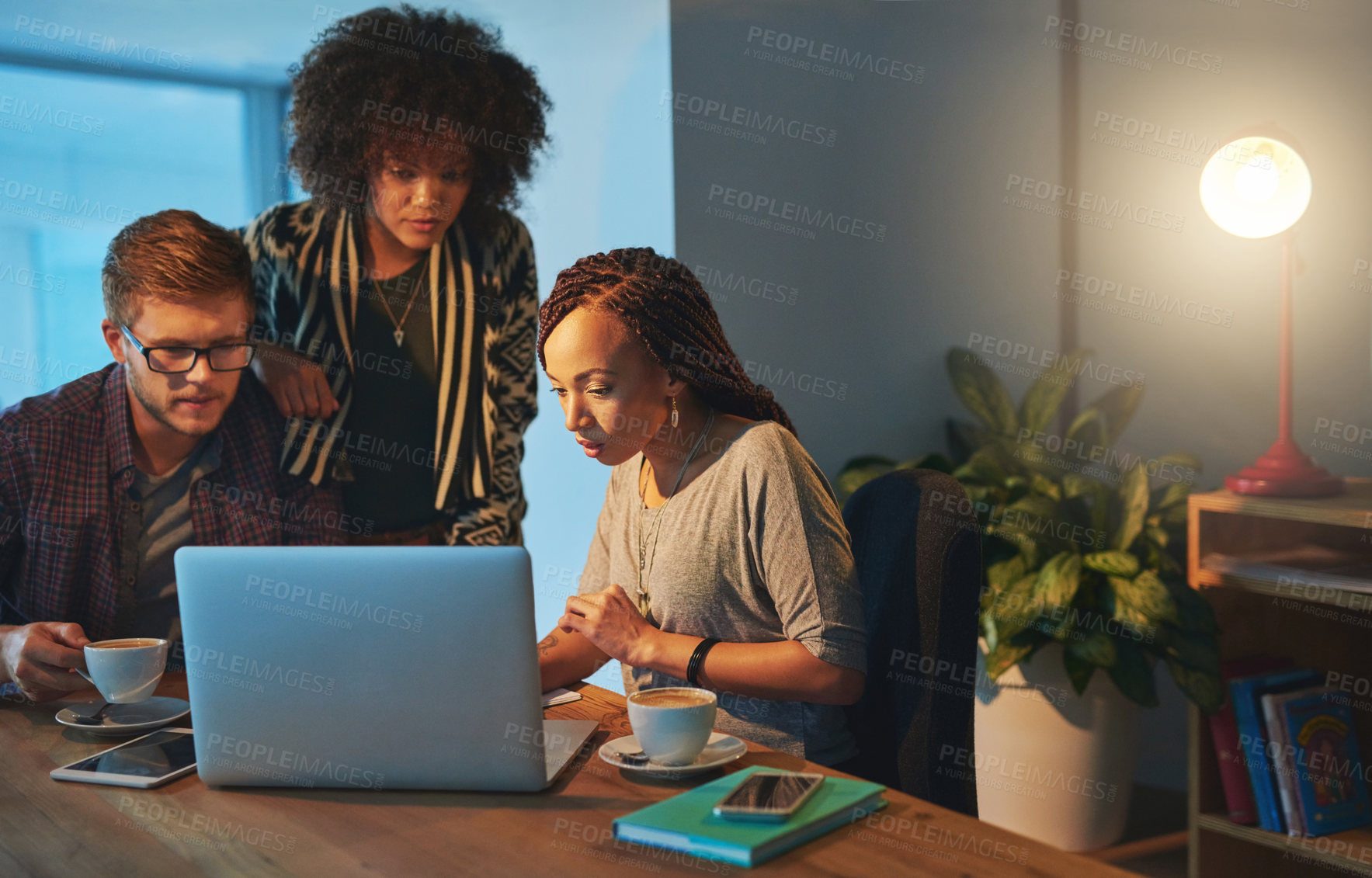 Buy stock photo Cropped shot of a group of young people working late in the office