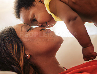 Buy stock photo Love, mother and kiss baby on sofa for relationship, bonding together and child development. Black family, woman and playing with kid in lounge for connection, attachment and security for wellness