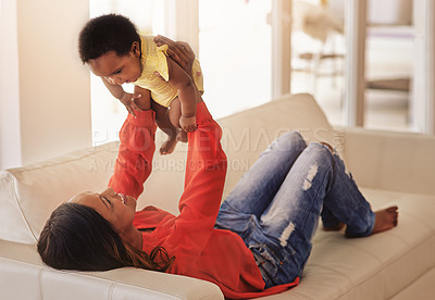 Buy stock photo Bonding, mother and playing with baby on sofa for lifting, connection and motor development. Black family, woman and support kid in living room with flying game, sensory stimulation or trust in home