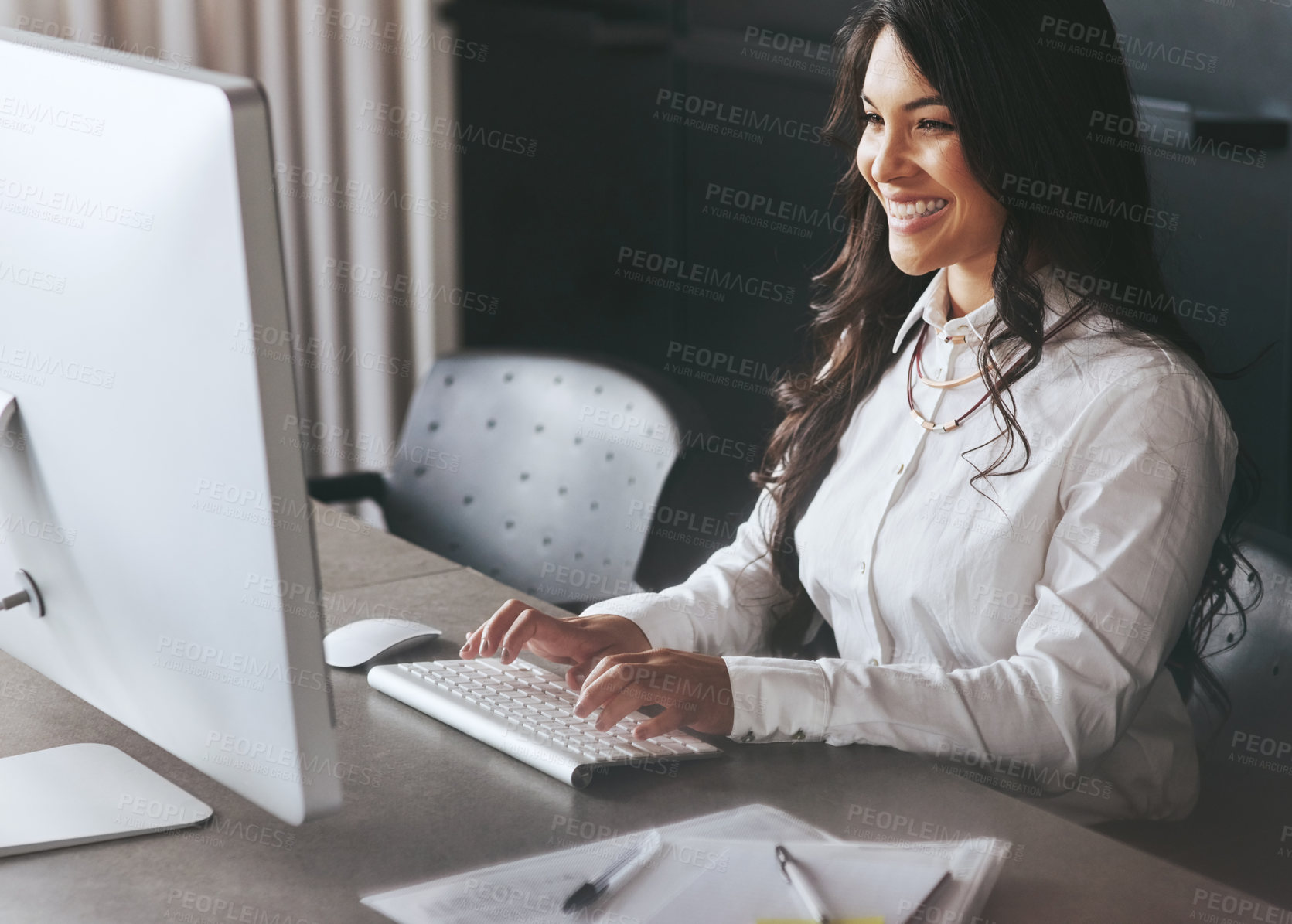 Buy stock photo Shot of a young businesswoman working on a computer at work